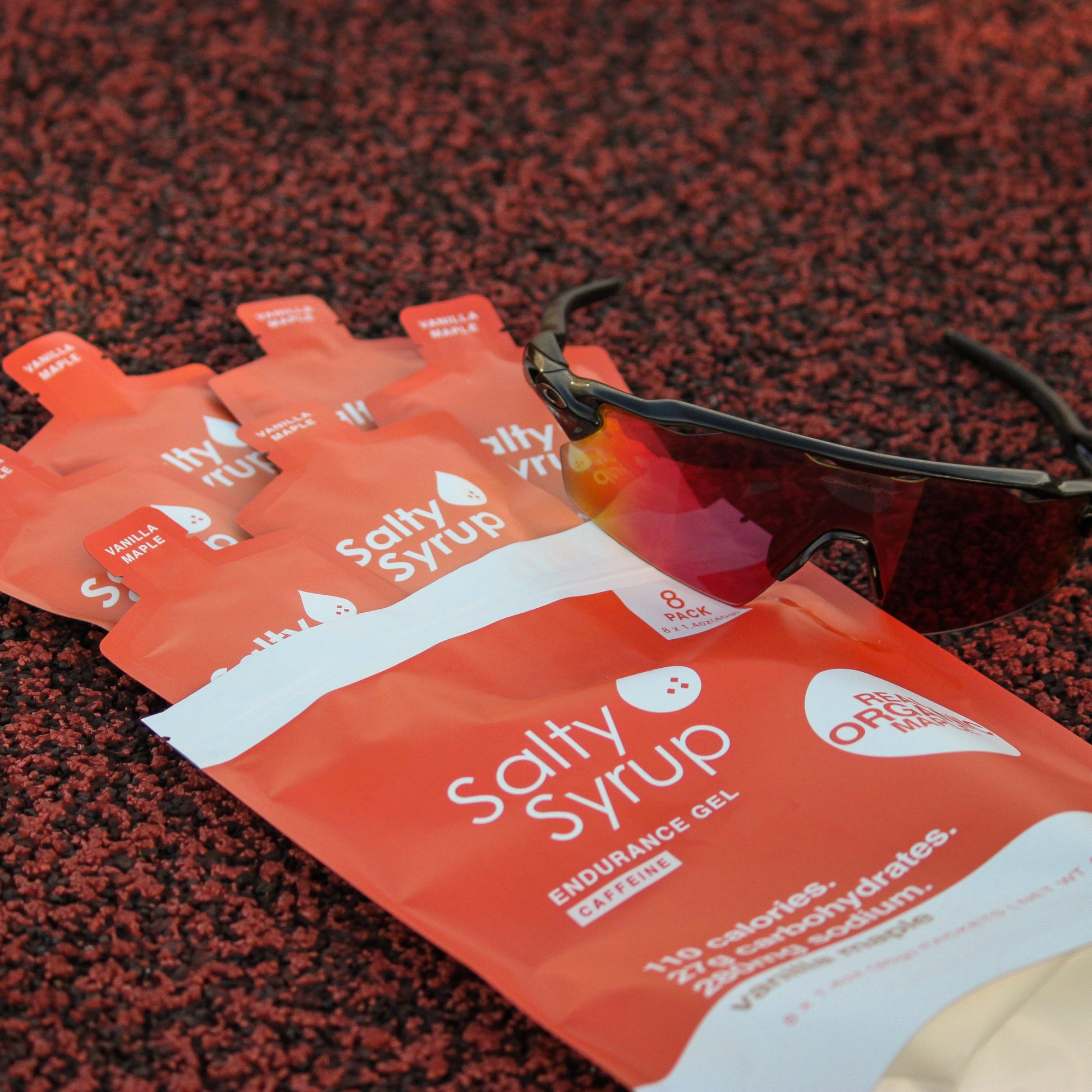 Salty Syrup Caffeinated gel 8-pack with sunglasses, track flat lay