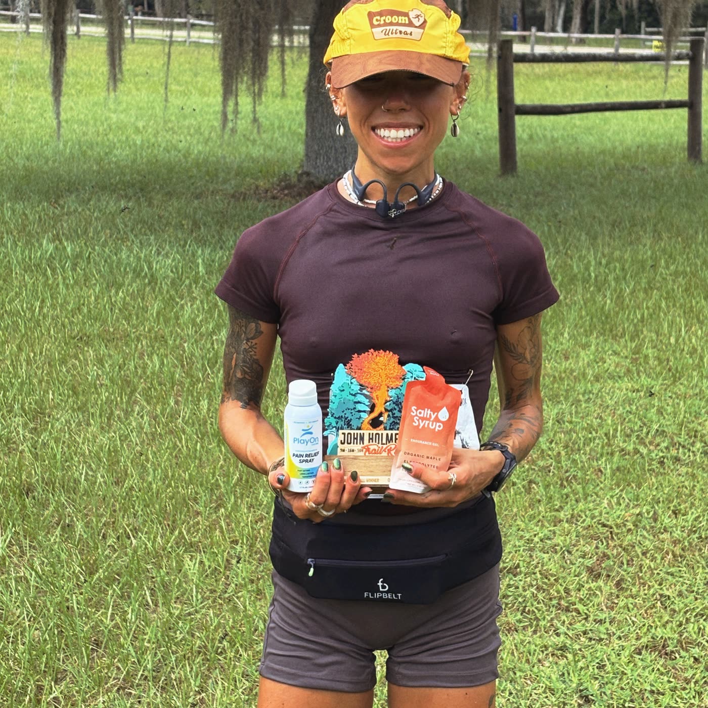 Hannah Horn holding her John Holmes race award, a Salty Syrup packet and a Play On Relief bottle